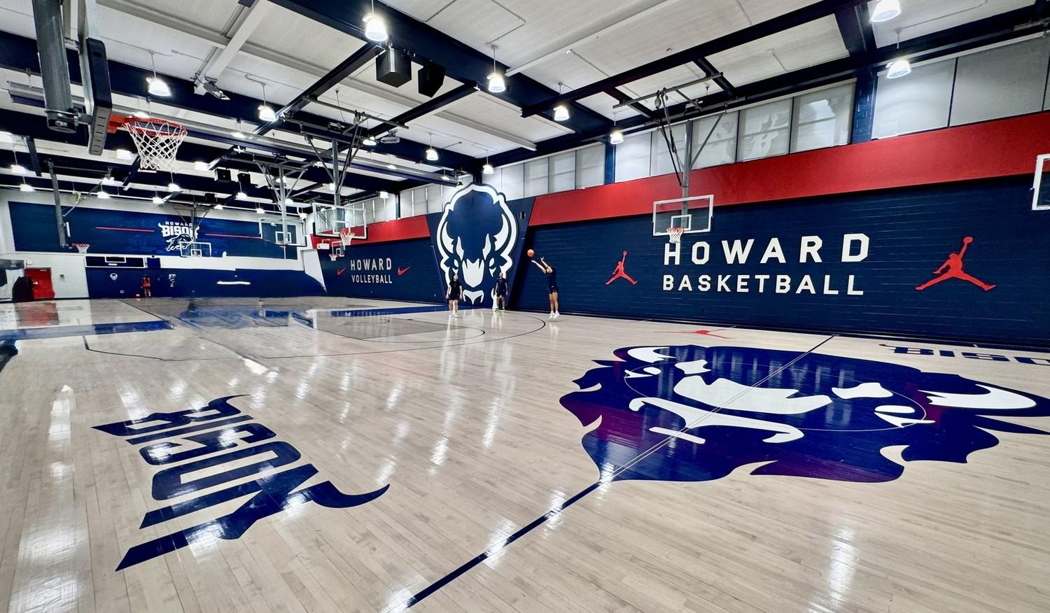 Completed hardwood gymnasium floor renovation at Howard University featuring navy blue and red court markings, Howard Bison logos, and custom HU center court design