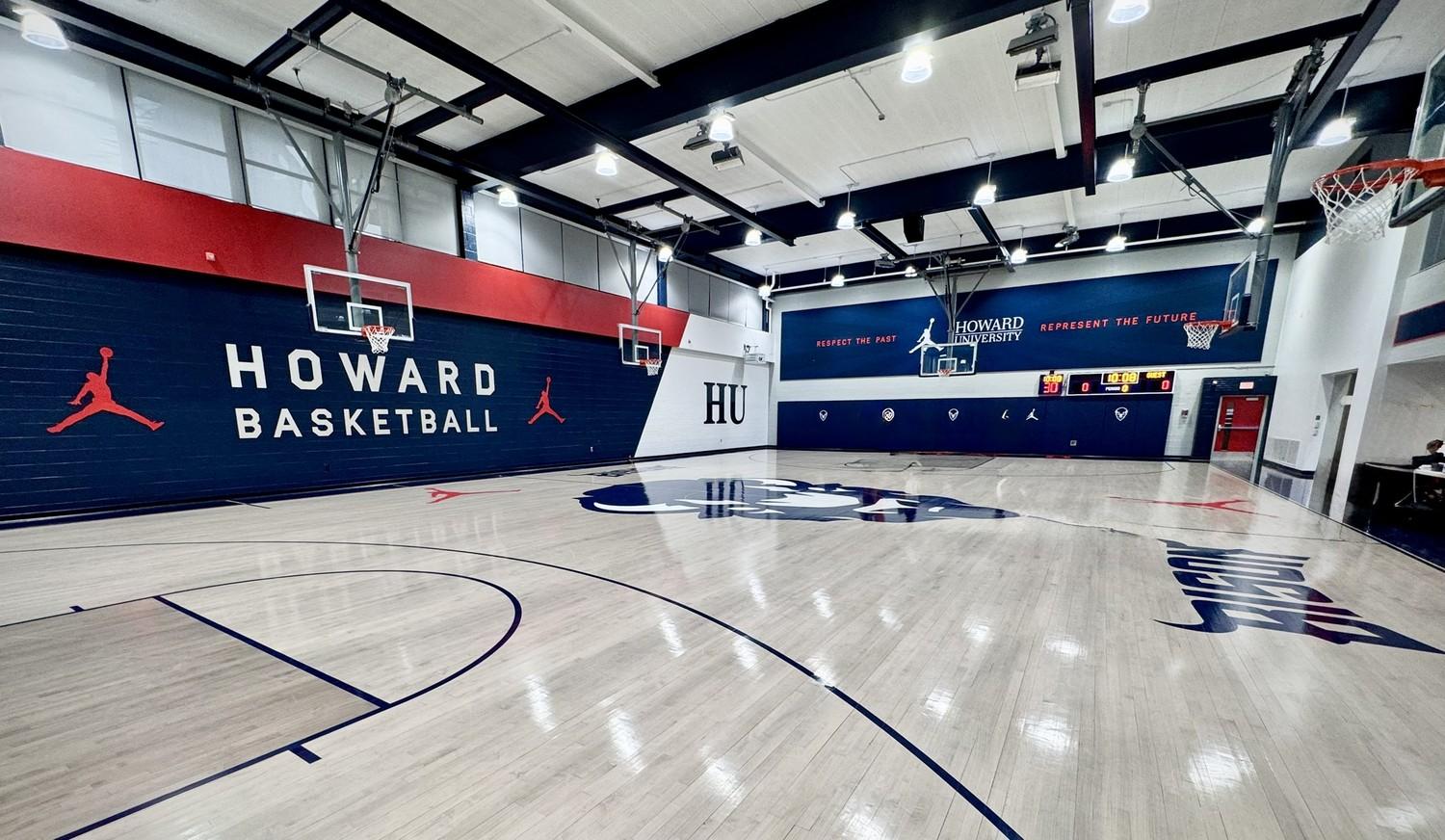 Completed hardwood gymnasium floor renovation at Howard University featuring navy blue and red court markings, Howard Bison logos, and custom HU center court design