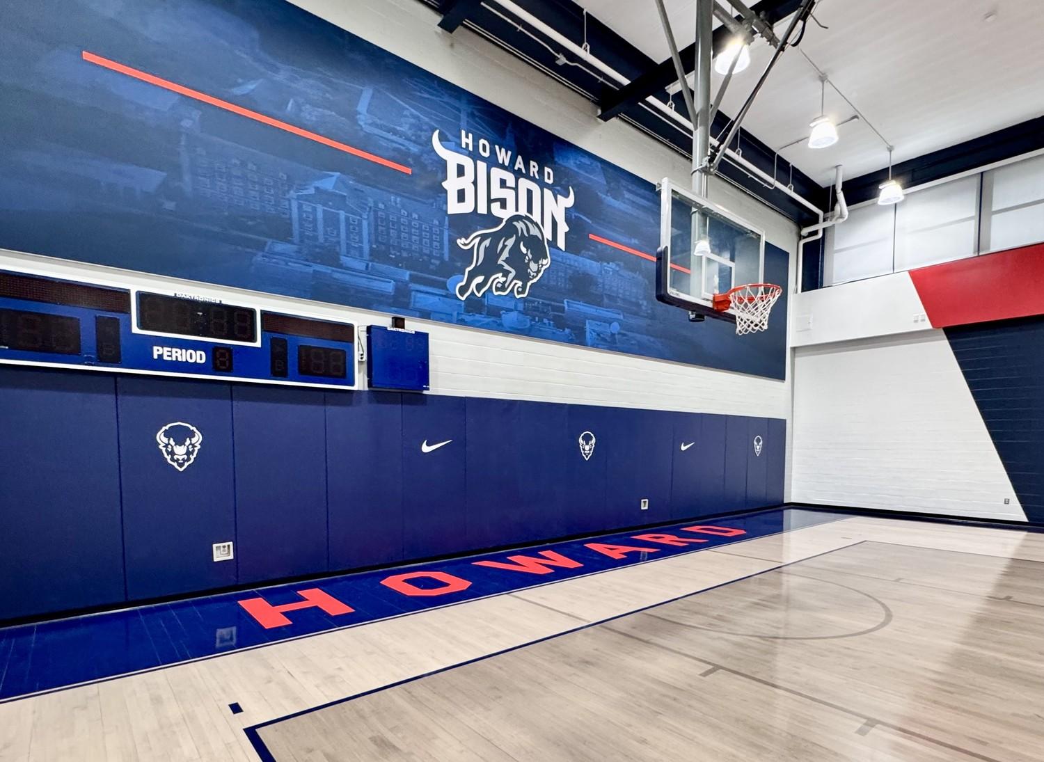 Completed hardwood gymnasium floor renovation at Howard University featuring navy blue and red court markings, Howard Bison logos, and custom HU center court design