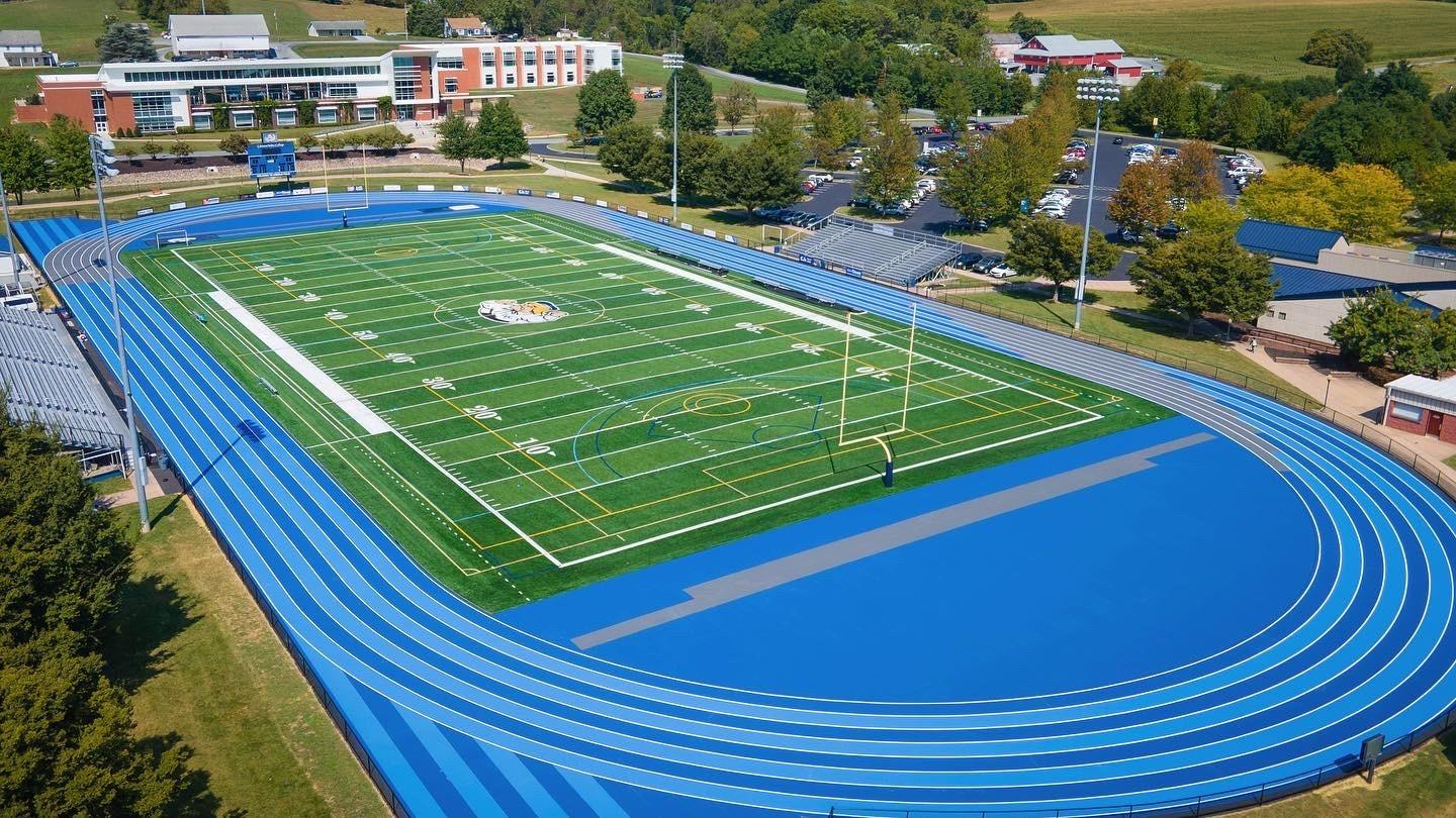 Completed Mondo track and field installation at Lebanon Valley College featuring bright blue running surface, multi-lane sprint straightaway, and green artificial turf infield