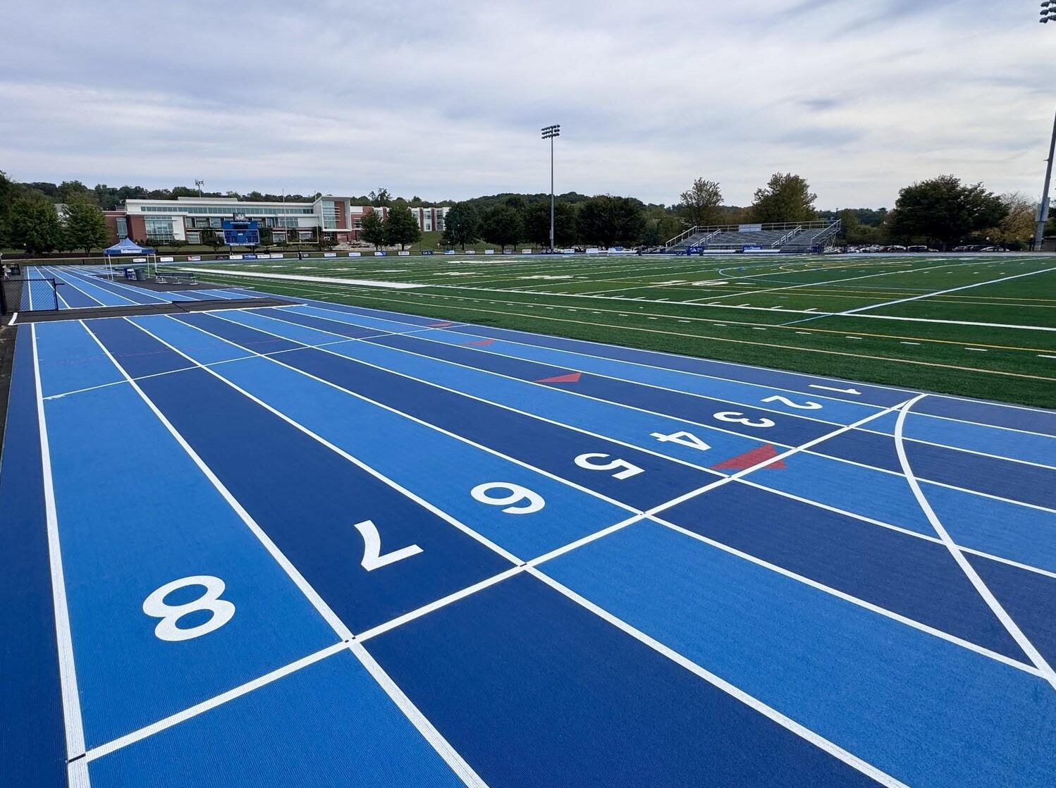Completed Mondo track and field installation at Lebanon Valley College featuring bright blue running surface, multi-lane sprint straightaway, and green artificial turf infield
