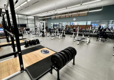 Completed fitness center and weight room renovation at Penn State Berks featuring cardio equipment, power racks, and Penn State Nittany Lion branding