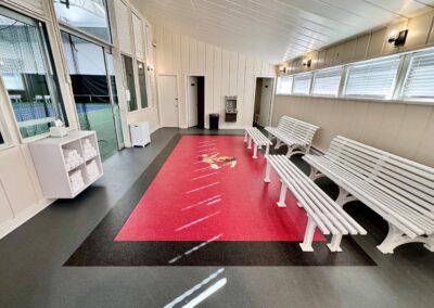Completed indoor flooring installation at Philadelphia Cricket Club featuring custom logo inlay and premium rubber sport surfacing