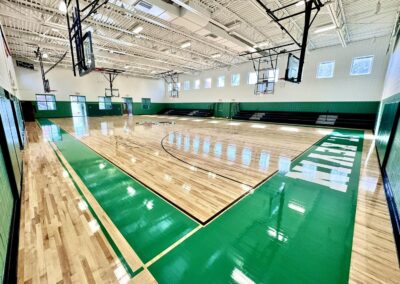 Completed hardwood gymnasium floor renovation at St. Kevin Parish of Springfield featuring green court markings, St. Kevin's Tigers logos, and fresh line striping