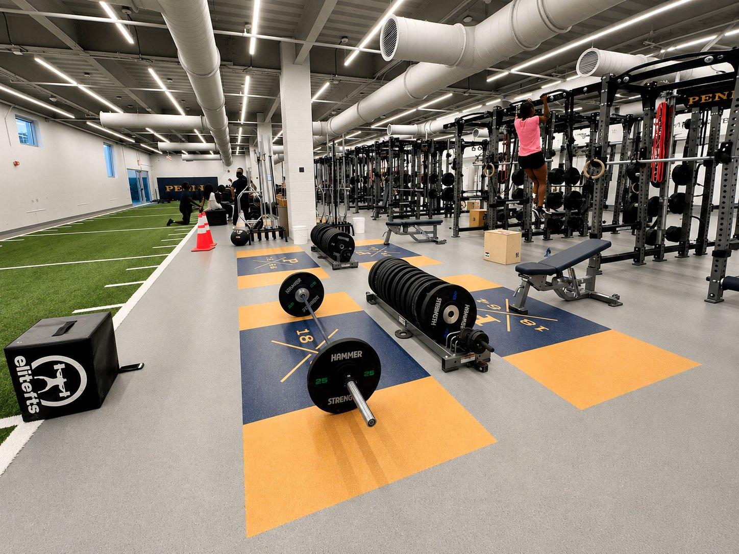 Full view of Peddie School Athletic Center weight room with Hammer Strength power racks, custom flooring, and athletes training
