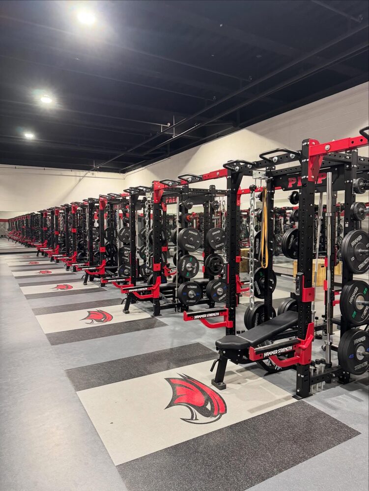 Row of Hammer Strength racks in the Saint Joseph's Prep weight room with custom mascot floor graphics