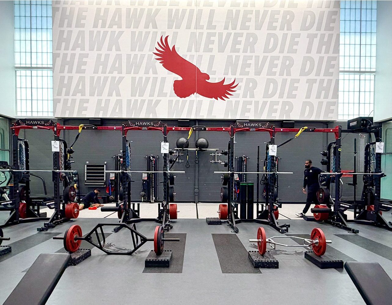 St. Joseph's University weight room close-up with a row of strength racks and hawk logo flooring beneath 